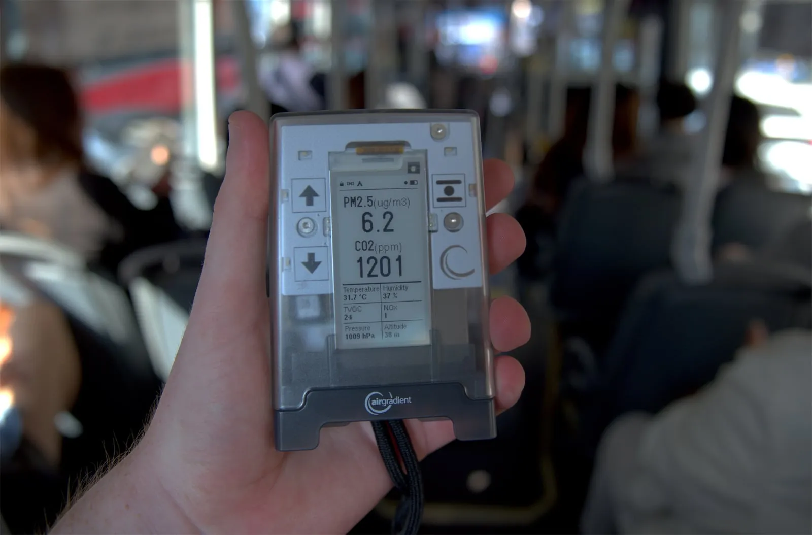 AirGradient Go held in one hand on a bus