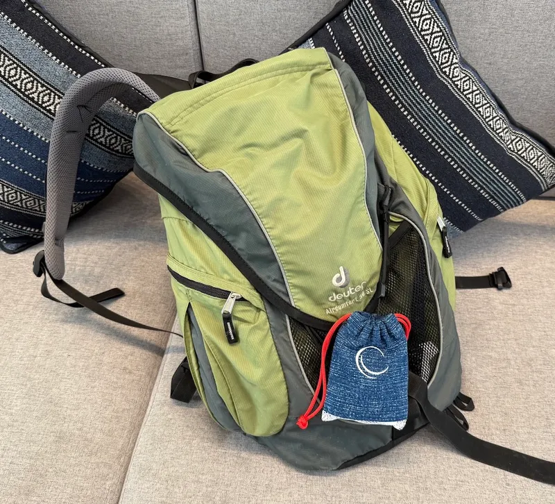 Backpack with a portable air quality monitor pouch attached